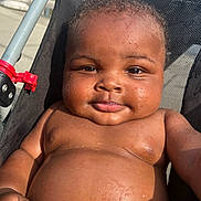 Johnivan is registered to the contest to win money with this photo: baby, child, water_droplets, stroller, sunlight, smile, skin, face, arm, chubby, outdoor, closeup, infant, seat, black_hair, expression, relaxing, summer, cute, portrait