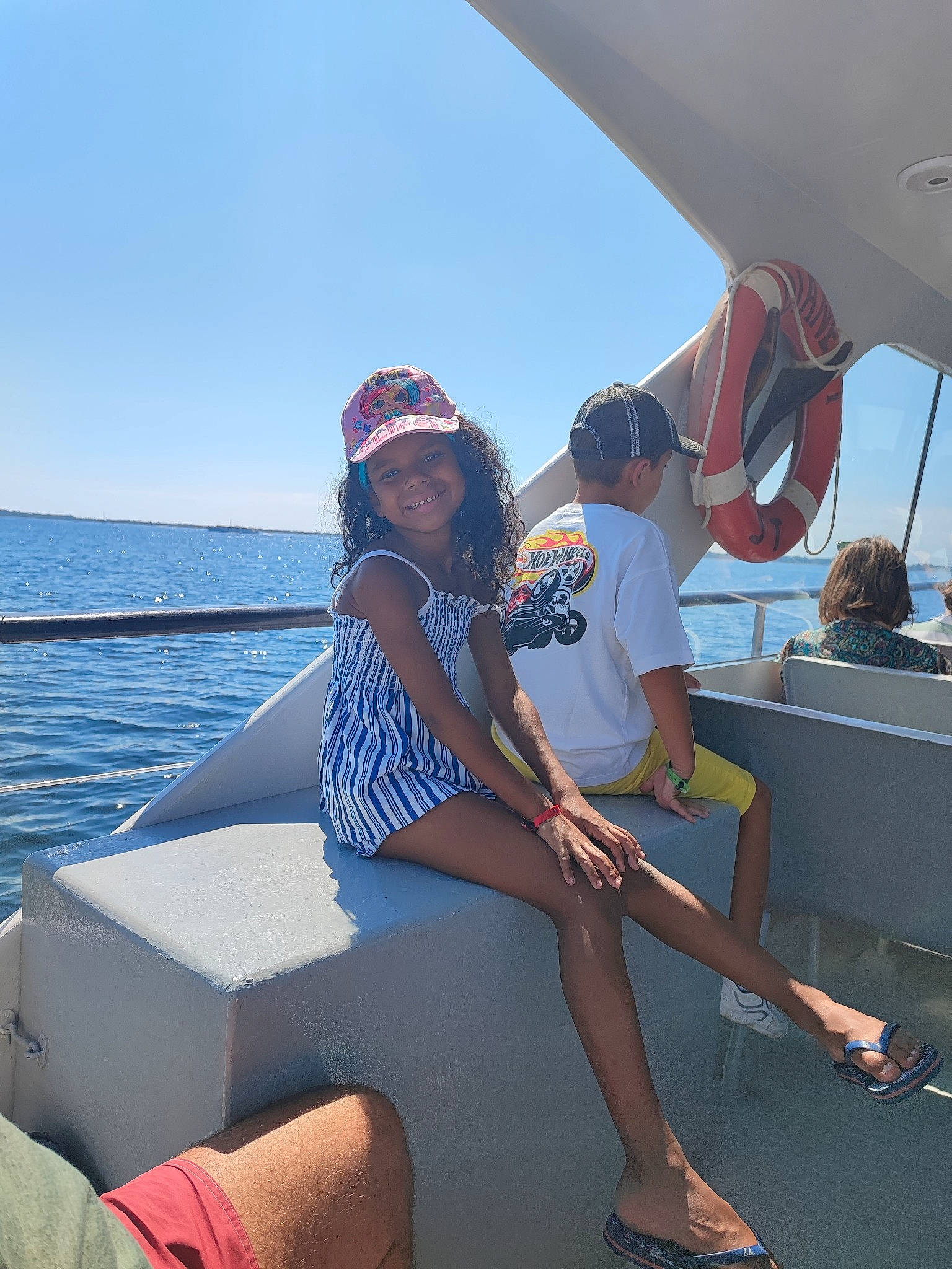 Eden participe au concours pour gagner de l'argent avec cette photo : boat, boats_and_boating_equipment_and_supplies, eyewear, hat, headwear, human_leg, joy, knee, lake, leisure, naval_architecture, person, recreation, sandal, ship, shorts, sky, thigh, travel, vehicle