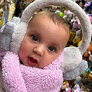 Raelynn joined the competition — help win amazing prizes! baby, child, face, earmuffs, scarf, pink, fluffy, soft, indoor, toys, stuffed_animals, colorful, closeup, winter_clothing, cute, portrait, warm, headwear, expression, person