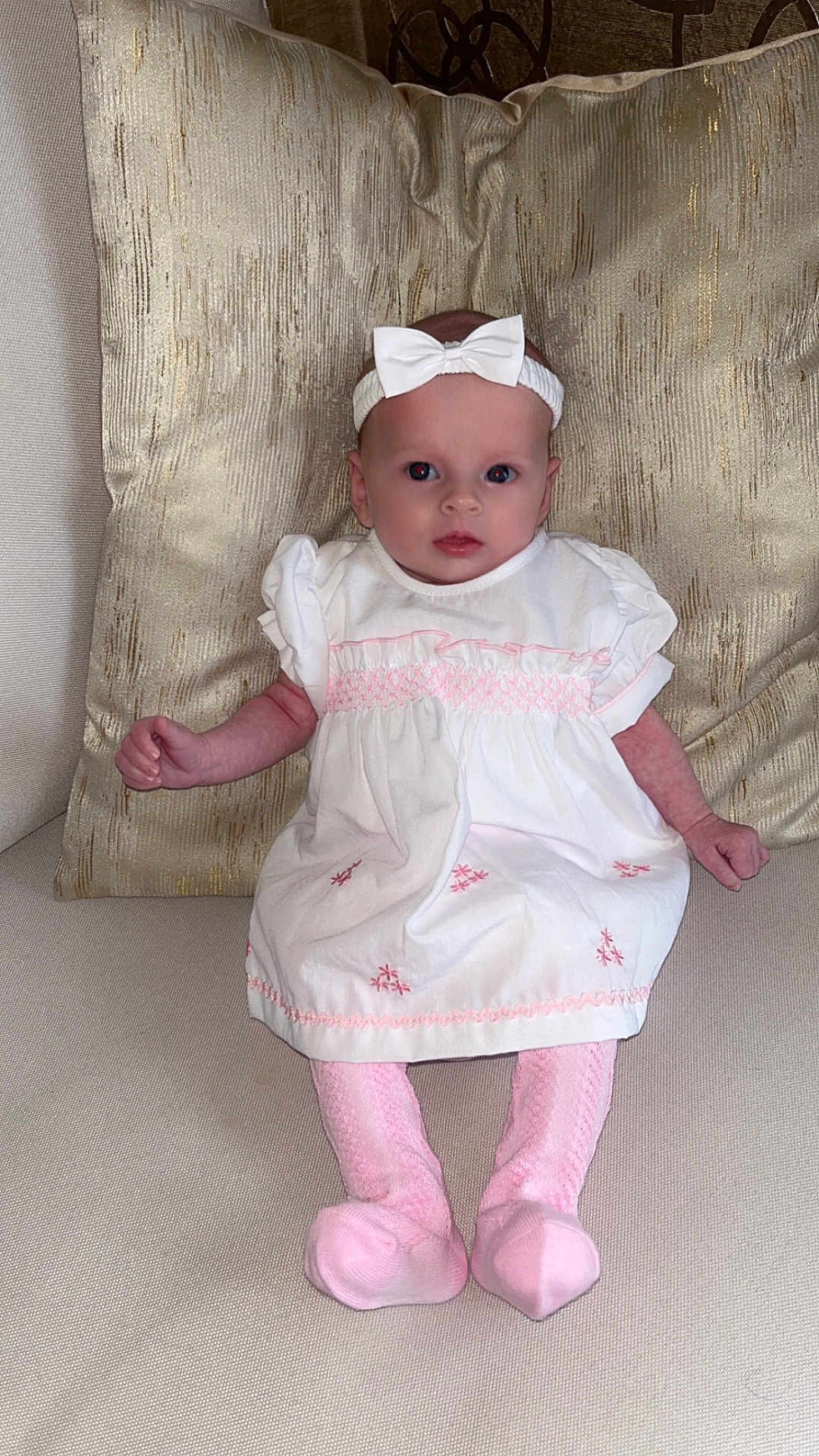 Havanna-Mai joined the competition — help win amazing prizes! baby, infant, white_dress, pink_socks, headband, bow, couch, pillow, golden_pillow, beige_couch, sitting, portrait, indoor, child, cute, small_hands, wide_eyes, soft_fabric, texture, comfortable