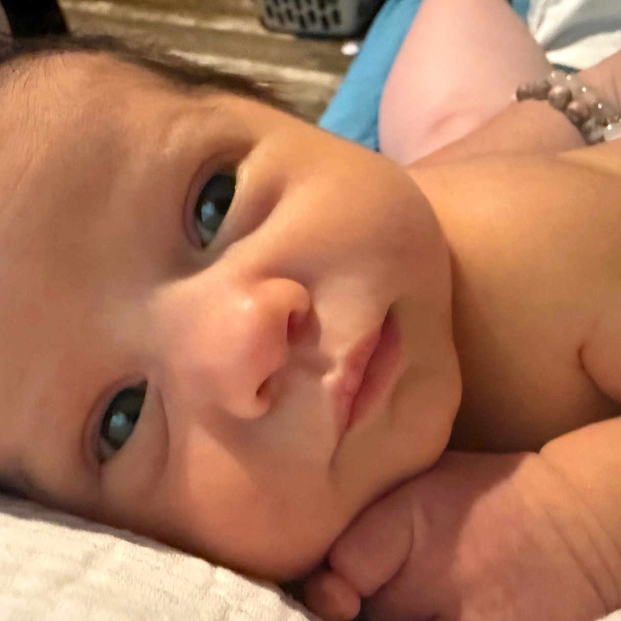 Erica is registered to the contest to win money with this photo: baby, child, closeup, curious, cute, expression, face, hand, human, indoors, infant, lying_down, newborn, peaceful, portrait, resting, skin, sleepy, soft_surface, young