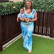 Kobie is registered to the contest to win money with this photo: baby, backyard, barefoot, bee_ornaments, blue_dress, casual, child, dress, family, fence, grass, happy, holding, leaf_decorations, outdoor, person, photography, portrait, smile, woman