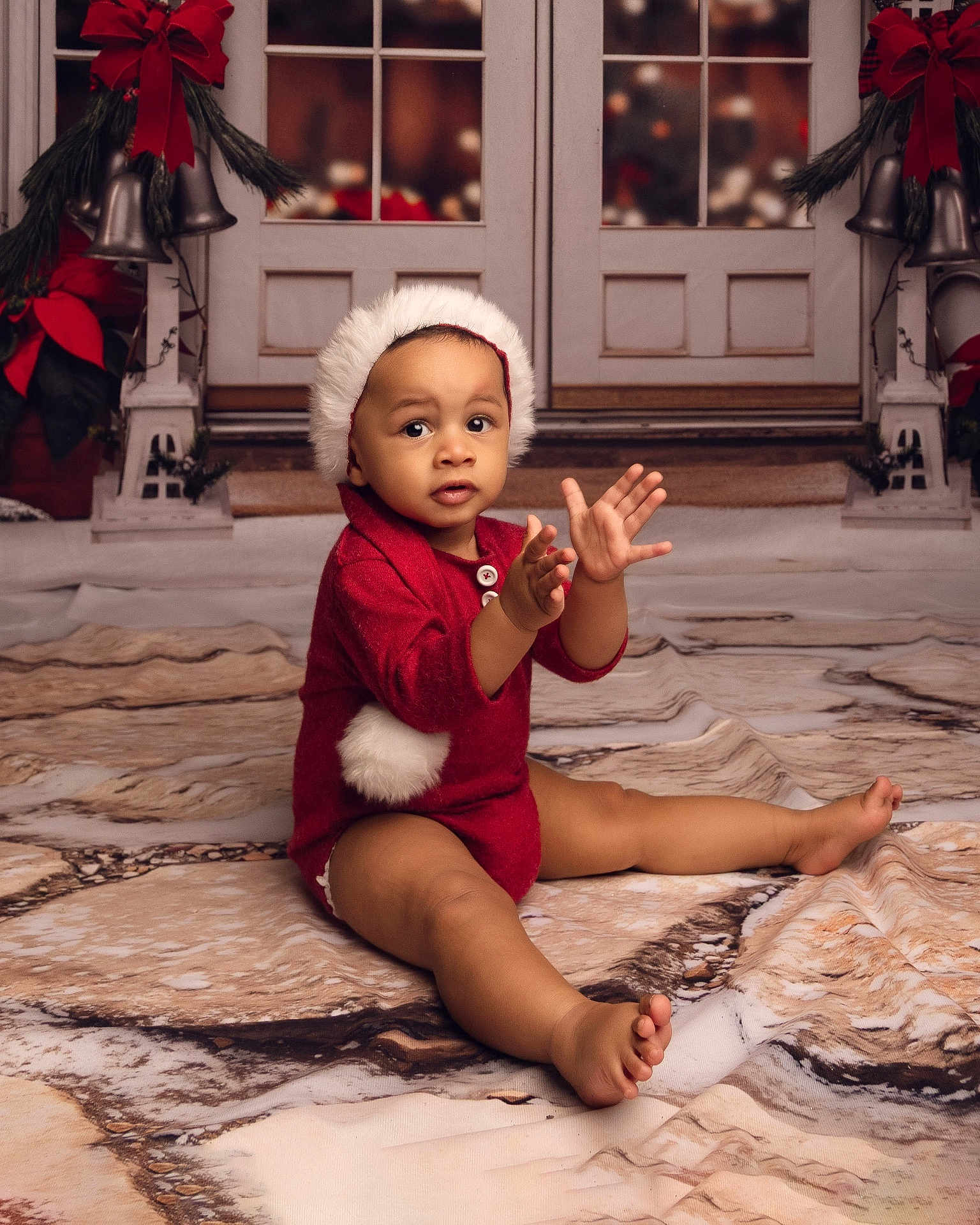 Kobie is registered to the contest to win money with this photo: baby, child, holiday, christmas, red_outfit, hat, pom_pom, clapping, curious, floor_covering, wreath, bells, decorations, indoor, festive, cute, sitting, portrait, young_child, celebration