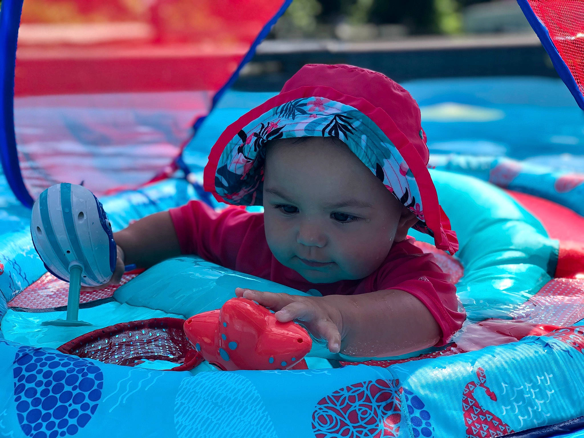 Miya is registered to the contest to win money with this photo: azure, baby, baby_products, baby_toddler_clothing, blue, child, fun, happy, headgear, headwear, leisure, outdoor_recreation, person, personal_protective_equipment, photograph, pink, recreation, red, snapshot, summer