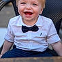 child, toddler, smiling, bow_tie, white_shirt, blue_pants, sitting, chair, outdoor, happy, face, blond_hair, cute, portrait, baby, fashion, casual, young, person, background_blur