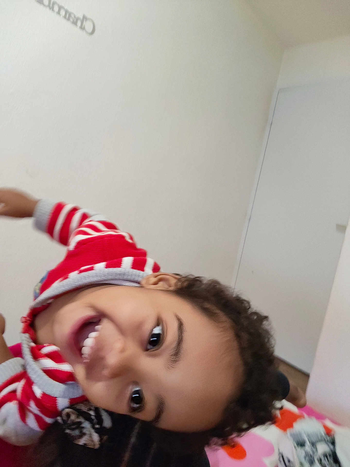 Jahime participe au concours pour gagner de l'argent avec cette photo : child, smiling, indoor, curly_hair, red_sweater, striped_clothing, happy, portrait, playful, bedroom, face, person, young, casual_clothing, expression, head, joyful, closeup, skin, eyes
