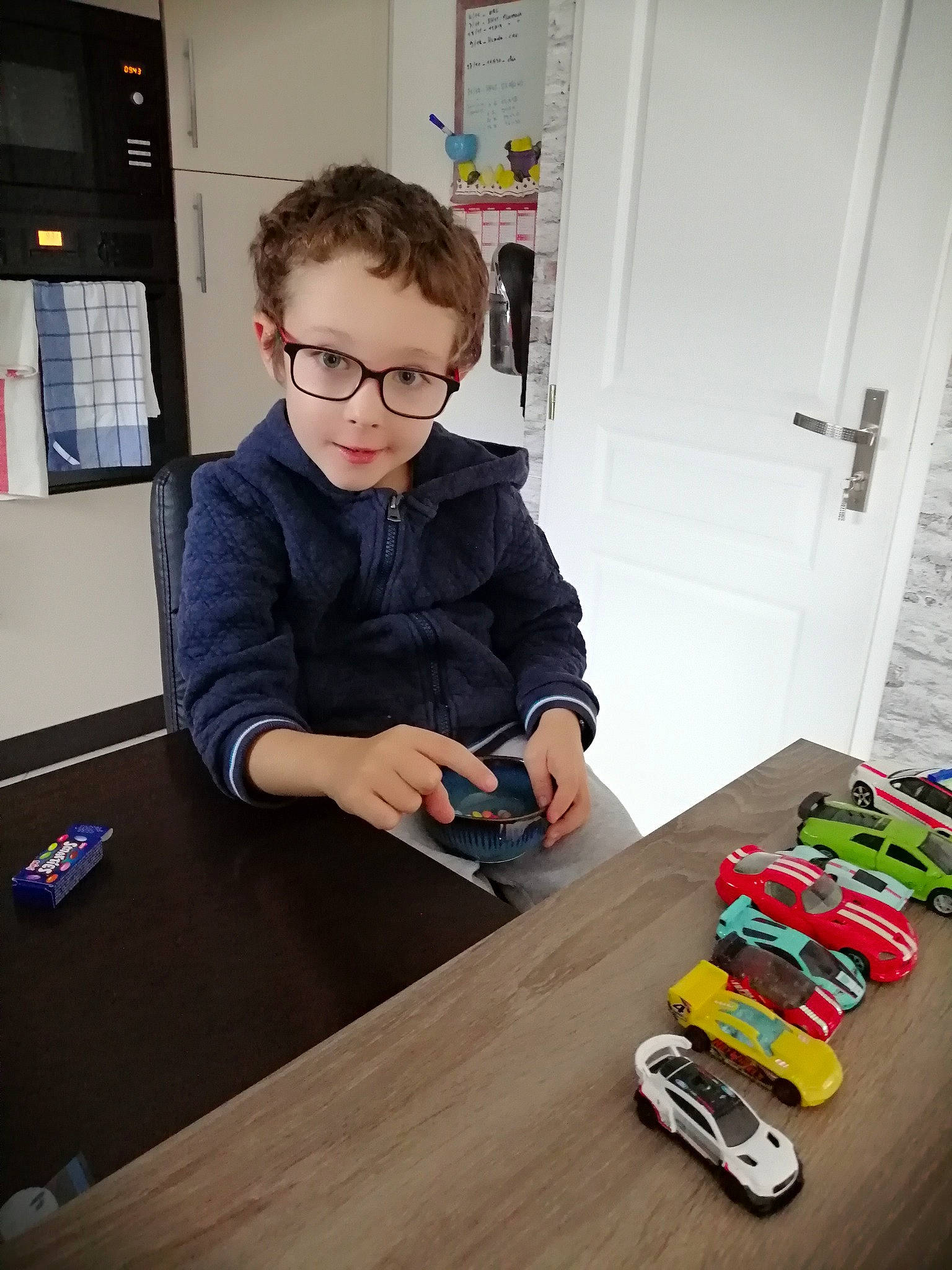 Augustin participe au concours pour gagner de l'argent avec cette photo : automotive_tire, chair, child, door, engineering, eyewear, flooring, fun, glasses, hardwood, person, room, table, tire, toddler, toy, toy_vehicle, varnish, wheel, wood