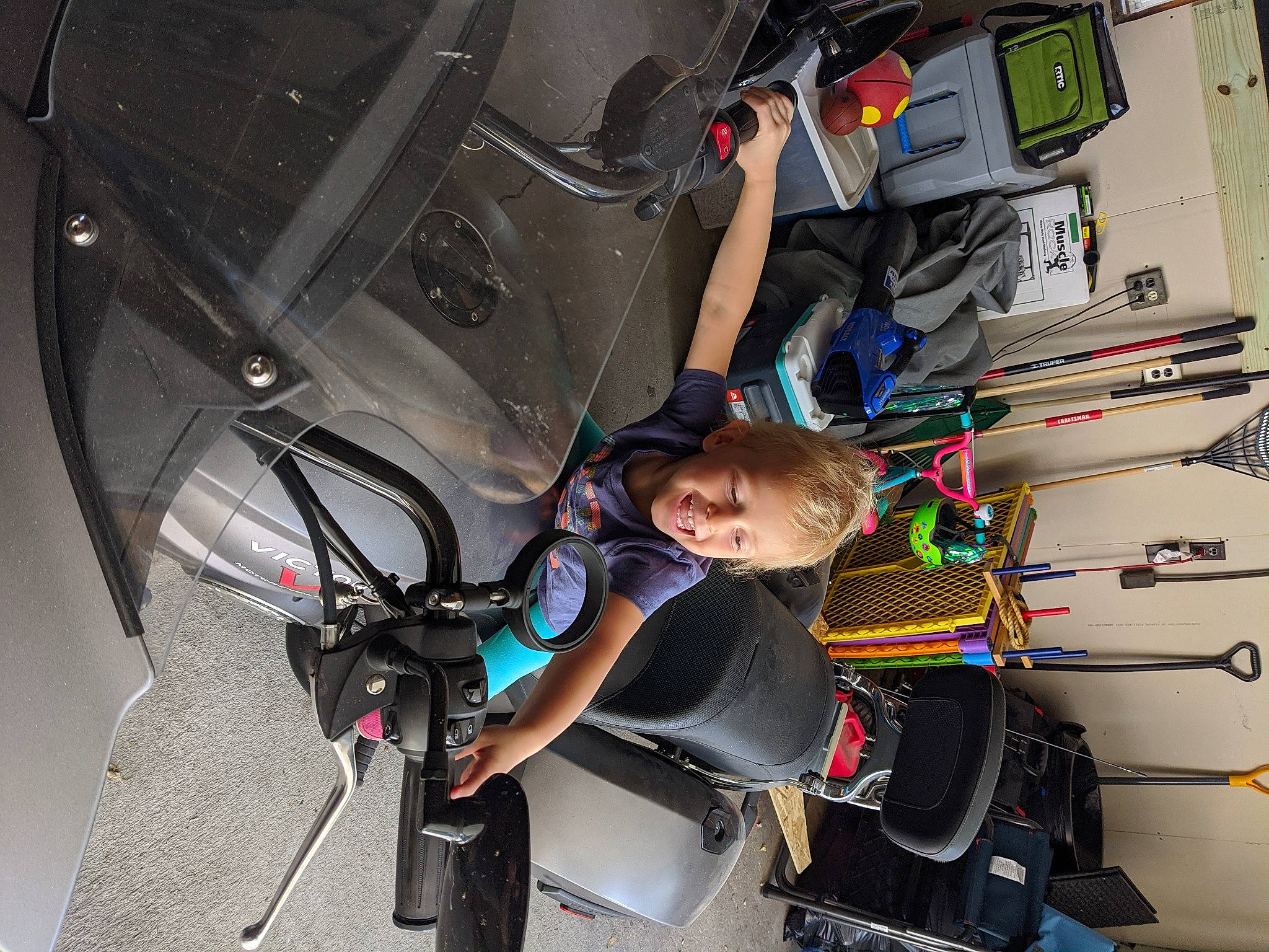 Harper is registered to the contest to win money with this photo: auto_part, automotive_design, automotive_exterior, automotive_tire, automotive_wheel_system, electrical_wiring, engineering, fun, hood, joy, machine, motor_vehicle, person, recreation, rim, smile, steering_wheel, t_shirt, technology, toddler