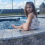 Baylynn joined the competition — help win amazing prizes! child, girl, pool, water, hot_tub, curly_hair, summer, outdoor, blue_sky, clouds, fence, stone_wall, dress, sitting, feet_in_water, yard, bench, sunny, daytime, relaxation
