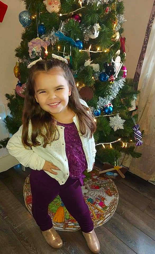 Maybelle is registered to the contest to win money with this photo: active_pants, beauty, branch, christmas, christmas_decoration, christmas_eve, christmas_ornament, christmas_tree, event, happy, holiday, holiday_ornament, joy, long_hair, ornament, person, plant, sleeve, smile, standing