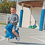 Yanis participe au concours pour gagner de l'argent avec cette photo : background, blue, boy, casual_clothing, child, daylight, friends, fun, happy, inflatable, jumping, outdoor, park, play, playground, recess, shorts, smiling, sneakers, toy