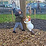Yanis participe au concours pour gagner de l'argent avec cette photo : boy, cars, child, daylight, fence, grass, jacket, leaves, outdoor, pants, park, person, playful, scarf, sneakers, snowman_statue, statue, tree, winter_hat, wood_chips
