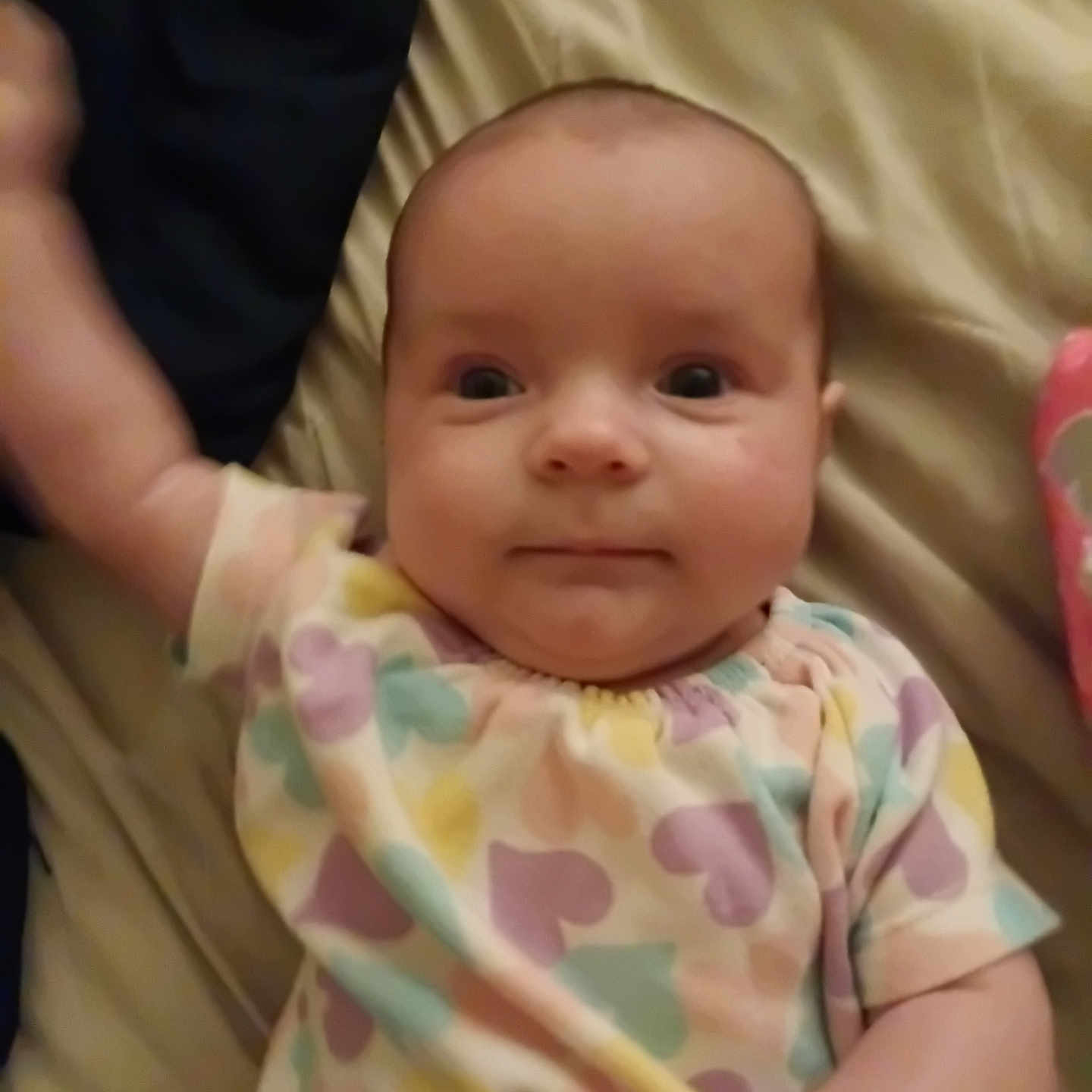 Lila joined the competition — help win amazing prizes! apparel, arm, baby, bed, blanket, child, cute, expression, face, hand, heart_pattern, indoors, infant, lying_down, pastel_colors, patterned_clothing, person, portrait, skin, young