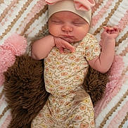 Scarlett joined the competition — help win amazing prizes! baby, sleeping, infant, headband, pink_bow, floral_pajamas, blanket, striped_blanket, cozy, cute, peaceful, child, soft_texture, brown_cushion, newborn, lying_down, indoors, adorable, resting, tiny_hands