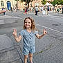 Olivia a rejoint le concours — aidez-le/la à gagner de superbes lots ! building, casual_clothing, child, concrete, crowd, daytime, event, girl, happy, outdoor, peace_sign, people, public_space, romper, sidewalk, smile, street, trees, urban, young