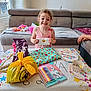 Olivia participe au concours pour gagner de l'argent avec cette photo : card, celebration, child, colorful, curtain, gift, girl, happy, indoor, living_room, markers, notebook, party, plate, present, smiling, sofa, table, toy, window