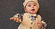 Ezeriel is registered to the contest to win money with this photo: baby, bow_tie, cap, carpet, child, clothing, cute, fashion, floor, indoor, infant, lying_down, pants, person, portrait, shirt, smiling, toddler, vest, young