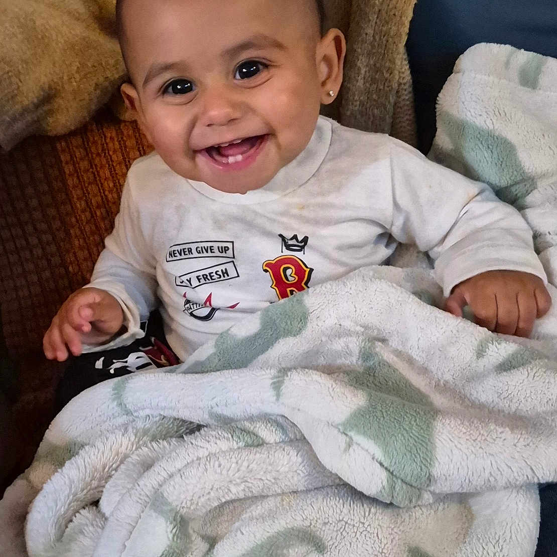 Ezeriel joined the competition — help win amazing prizes! baby, blanket, child, clothing, comfort, couch, cozy, cute, earrings, expression, furniture, happy, indoors, person, portrait, sitting, smiling, soft, toddler, warm