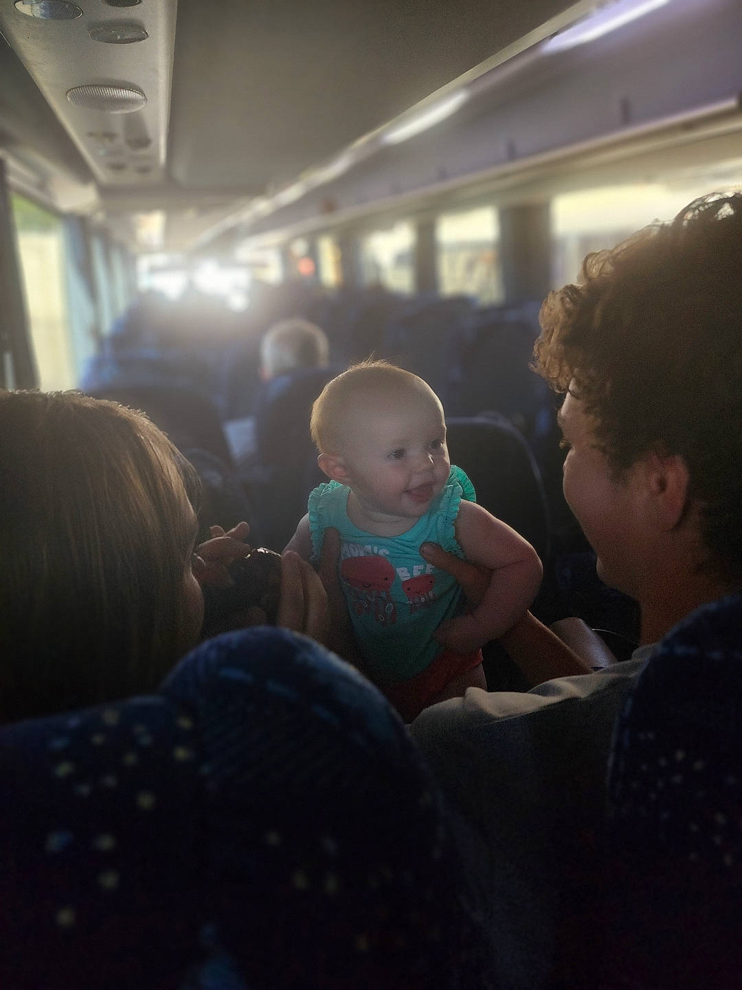 Hailey is registered to the contest to win money with this photo: air_travel, baby, child, cloud, crowd, event, fun, happy, hat, interaction, night, passenger, passenger_car, person, public_transport, room, sitting, t_shirt, toddler, travel