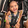 baby, car_seat, smiling, child, safety_harness, hair_clips, colorful, striped_clothing, happy, cute, infant, indoors, seat, toy, person, portrait, childcare, secure, expression, closeup
