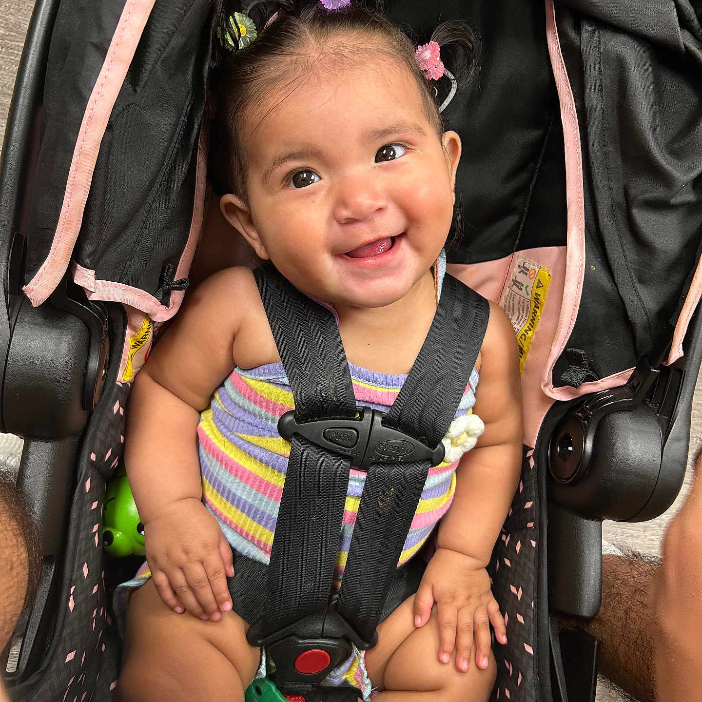 Lilah joined the competition — help win amazing prizes! baby, car_seat, child, childcare, closeup, colorful, cute, expression, hair_clips, happy, indoors, infant, person, portrait, safety_harness, seat, secure, smiling, striped_clothing, toy