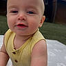 James is registered to the contest to win money with this photo: baby, child, smiling, yellow_top, patterned_pants, outdoor, grass, building, curious, happy, close_up, infant, person, portrait, cute, young_child, skin, face, arm, daylight