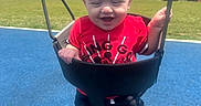 James joined the competition — help win amazing prizes! toddler, child, swing, playground, red_shirt, mickey_mouse, outdoor, sunny, blue_mat, grass, sky, clouds, happy, smiling, legs, metal_chain, summer, fun, person, daytime