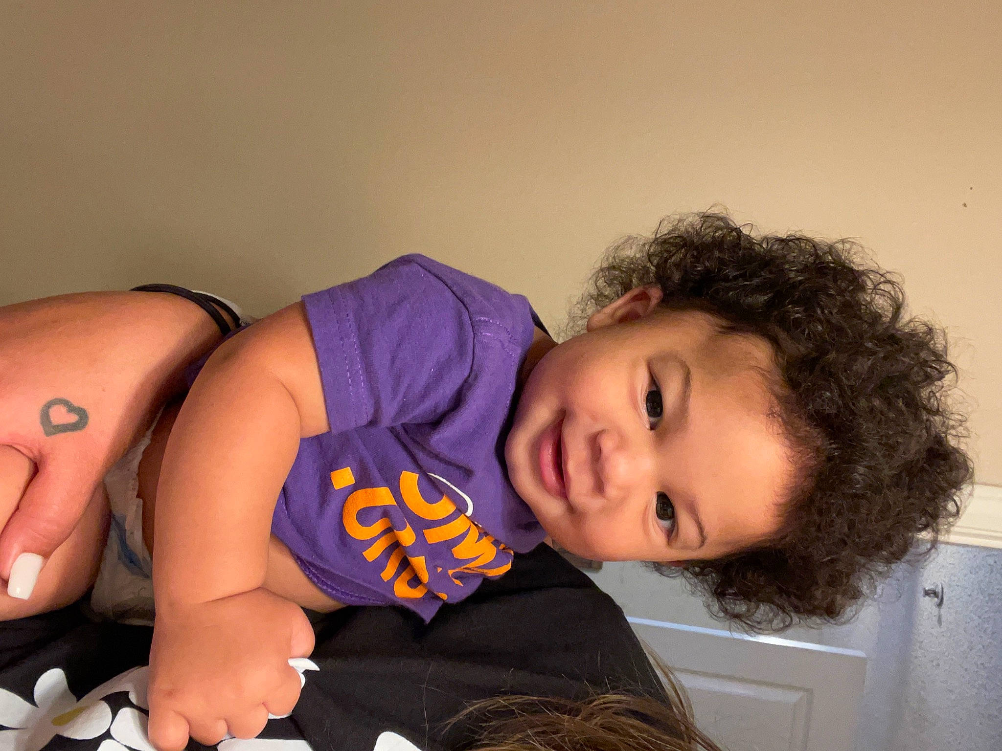 Ezekiel is registered to the contest to win money with this photo: abdomen, arm, black_hair, cheek, chest, child, comfort, elbow, eyelash, fun, happy, human_leg, knee, mouth, neck, person, shoulder, thigh, toddler, trunk