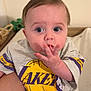 Pablo participe au concours pour gagner de l'argent avec cette photo : baby, child, lakers, clothing, grey_outfit, basketball_logo, indoor, person, hand, face, blue_eyes, short_hair, tattoo, sitting, cute, infant, looking_up, casual, home, portrait