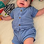 baby, infant, blue_clothing, smiling, lying_down, playpen, toy, soft_toys, quilted_surface, indoor, cute, child, happy, face, person, buttoned_shirt, shorts, colorful, play_area, comfort