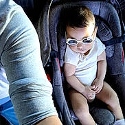 éden a rejoint le concours — aidez-le/la à gagner de superbes lots ! baby, car_seat, sunglasses, white_clothing, infant, child, seatbelt, person, legs, arm, casual, footwear, indoor, cute, young, relaxed, fashion, accessory, portrait, toddler
