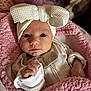 Nyah is registered to the contest to win money with this photo: baby, infant, headband, bow, blanket, pink, clothing, face, hand, dog, pet, fur, eyes, portrait, cozy, soft, indoor, cute, newborn, child
