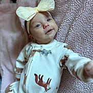 Nyah is registered to the contest to win money with this photo: baby, infant, bow, headband, blanket, onesie, animal_print, pink, soft_texture, cute, smiling, reaching_out, portrait, child, newborn, cozy, fabric, sleepwear, happy, face
