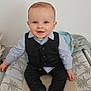 baby, child, smiling, sitting, indoor, vest, shirt, sock, changing_table, blanket, happy, portrait, cute, infant, clothing, face, person, furniture, home, young
