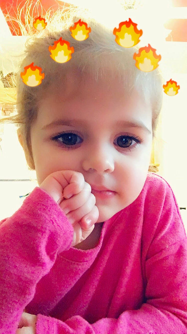 Amelia is registered to the contest to win money with this photo: baby, cheek, child, close_up, face, finger, gesture, hand, head, lip, mouth, nose, person, pink, skin, smile, thumb, toddler