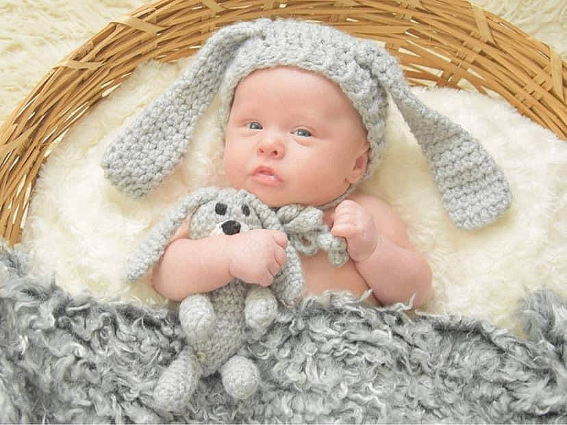 Ollie joined the competition — help win amazing prizes! baby, baby_sleeping, baby_toddler_clothing, basket, cap, comfort, doll, eye, fashion_accessory, fawn, fur, grass, headwear, iris, linens, person, skin, textile, toddler, toy