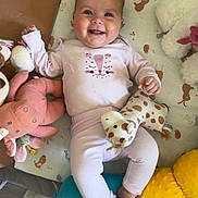 Valentine participe au concours pour gagner de l'argent avec cette photo : baby, smiling, infant, stuffed_animal, giraffe_toy, play_mat, cute_clothing, happy, child, toy, soft_toy, pink_outfit, lying_down, indoor, colorful, face, feet, hands, cuddly, cozy
