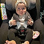 baby, child, car_seat, maxi_cosi, headband, heart_pattern, clothing, straps, safety, foot, barefoot, infant, seatbelt, cute, looking, indoors, person, smiling, playful, closeup