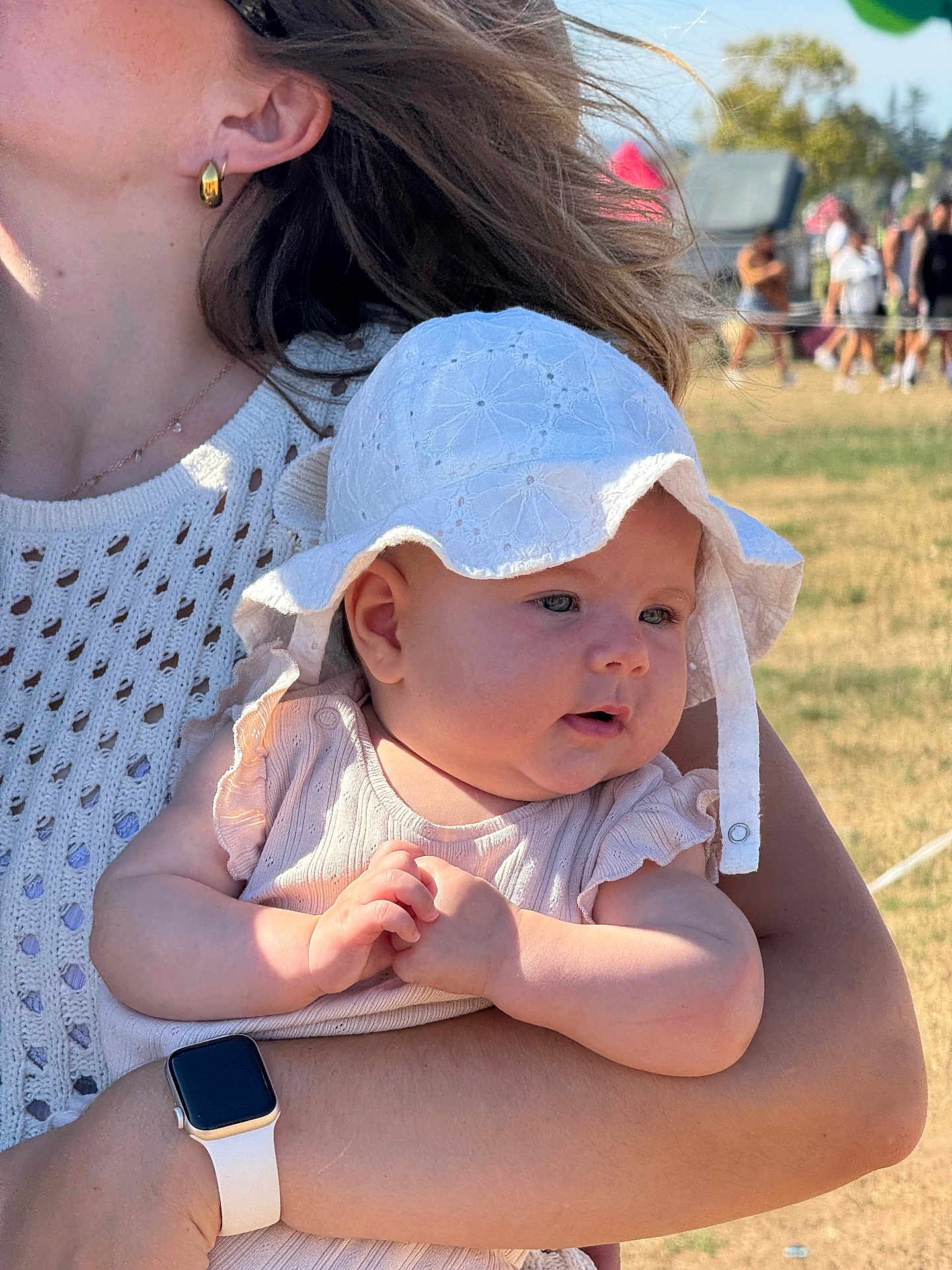 Valentine participe au concours pour gagner de l'argent avec cette photo : baby, child, hat, white_hat, adult, arm, watch, earring, outdoor, sunlight, grass, people, crowd, summer, portrait, closeup, holding, clothing, person, daytime