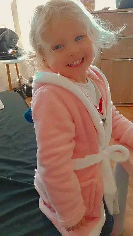 Emma participe au concours pour gagner de l'argent avec cette photo : arm, baby_toddler_clothing, blond, cheek, child, eye, face, flooring, fun, gesture, happy, iris, joy, lip, person, pink, skin, sleeve, smile, thumb