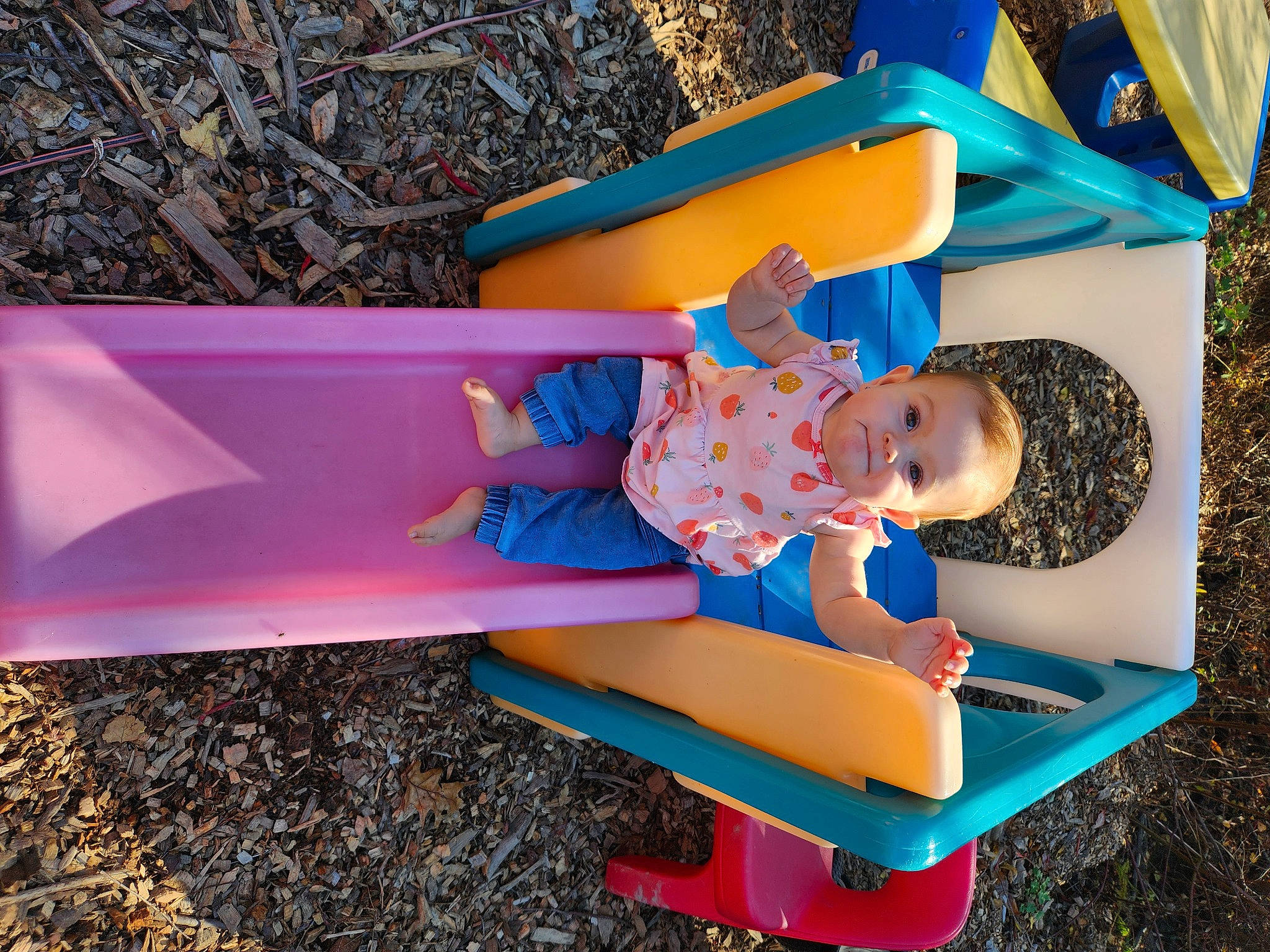 Reagan is registered to the contest to win money with this photo: baby_toddler_clothing, bench, blue, child, chute, city, clothing, electric_blue, fun, grass, leisure, outdoor_furniture, outdoor_play_equipment, people_in_nature, person, plastic, play, recreation, sitting, toddler