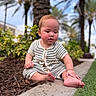 baby, child, outdoor, garden, plant, mulch, pathway, greenery, palm_tree, curious, sitting, foot, hand, short_sleeve, striped_clothing, nature, daylight, portrait, cute, infant