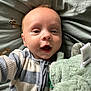 Harri joined the competition — help win amazing prizes! baby, infant, child, face, smiling, plush_toy, blanket, striped_clothing, bed, cute, portrait, happy, soft_toy, indoor, young_child, closeup, person, cozy, sleepwear, lying_down