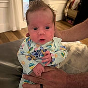 Dominic joined the competition — help win amazing prizes! baby, infant, hands, pajamas, person, face, indoor, furniture, curious, wood_floor, window, adult, holding, clothing, portrait, cute, expression, sitting, home, soft_lighting