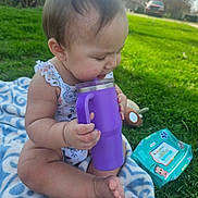 Jaylani joined the competition — help win amazing prizes! baby, baby_wipes, blanket, casual, child, cute, drinking, grass, greenery, infant, nature, outdoor, playtime, portrait, purple_cup, sitting, summer, sunlight, toy, young_child