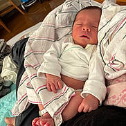 Jesse is registered to the contest to win money with this photo: newborn, baby, sleeping, blanket, hospital_bracelet, infant, hand, foot, clothing, striped, person, indoor, bedroom, resting, cozy, skin, face, small_toes, wrapped, comfort