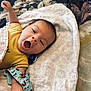 Jesse is registered to the contest to win money with this photo: baby, yawning, blanket, onesie, infant, pacifier, strap, dog_pattern, lying_down, cute, child, sleepy, indoors, soft_texture, closeup, face, arm, skin, resting, toddler