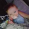 Brandon joined the competition — help win amazing prizes! baby, pacifier, blanket, couch, blue_clothing, arm, tattoo, face, child, resting, indoor, closeup, messy_face, comfort, sleepy, human, person, soft_texture, cozy, relaxed