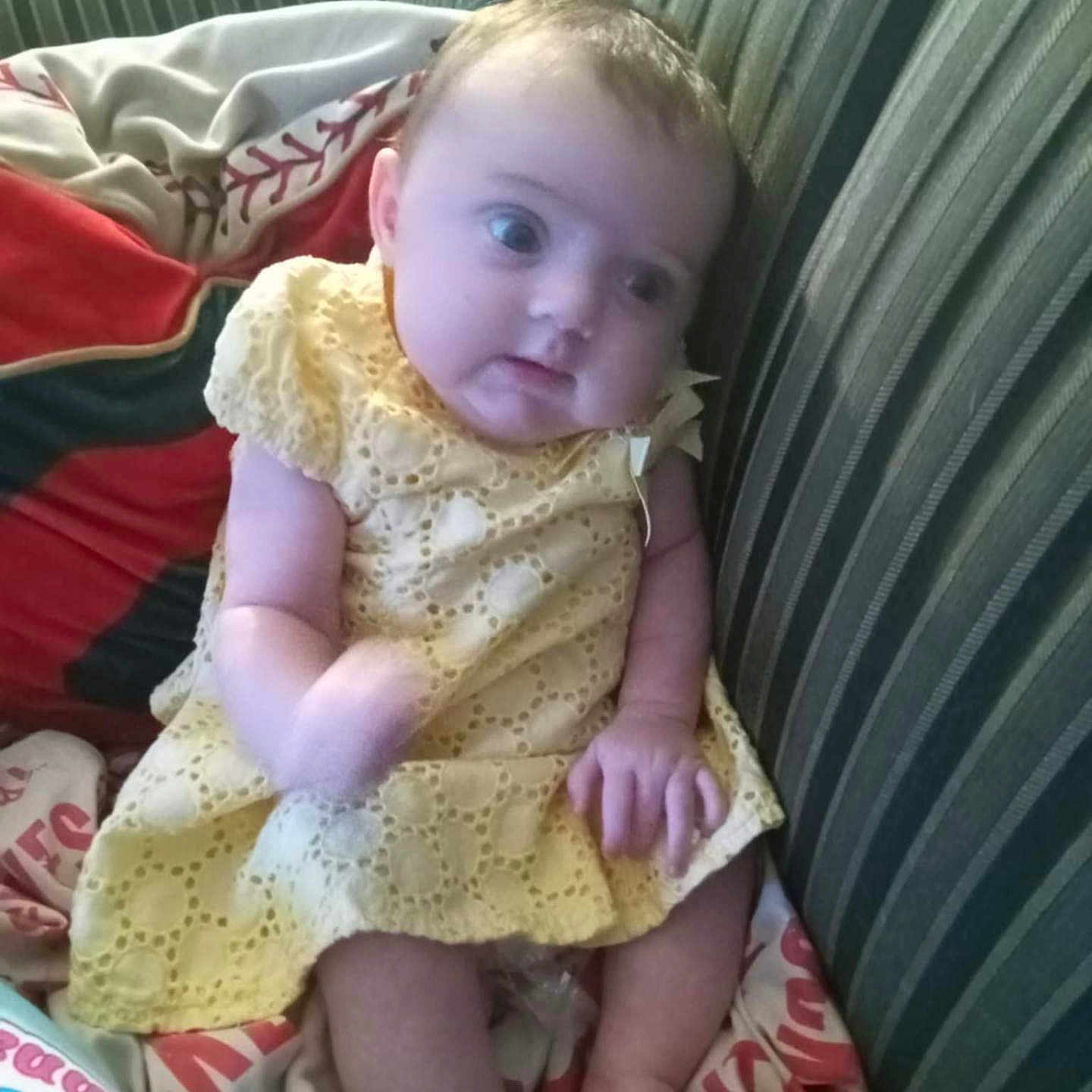 Emma joined the competition — help win amazing prizes! baby, bed, bedroom, clothing, couch, cushion, dress, face, furniture, head, homedecor, indoors, linen, person, photography, pillow, portrait, quilt, room, sitting