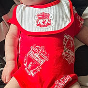 Ava-Mae is registered to the contest to win money with this photo: arms, baby, bed, bib, blanket, cute, football_club_logo, head, indoors, infant, legs, liverpool, newborn, onesie, person, red_clothing, rest, skin, sleeping, soft_light